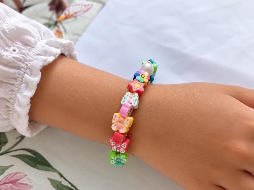 Un bracelet haut en couleurs 🌈 Bracelet coloré réalisé avec des perles fantaisie en forme de fleurs, étoiles et papillons